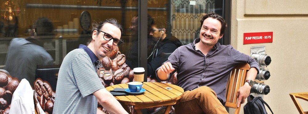 A photo of Laurent and Michael in San Francisco, on the patio of a coffee shop.