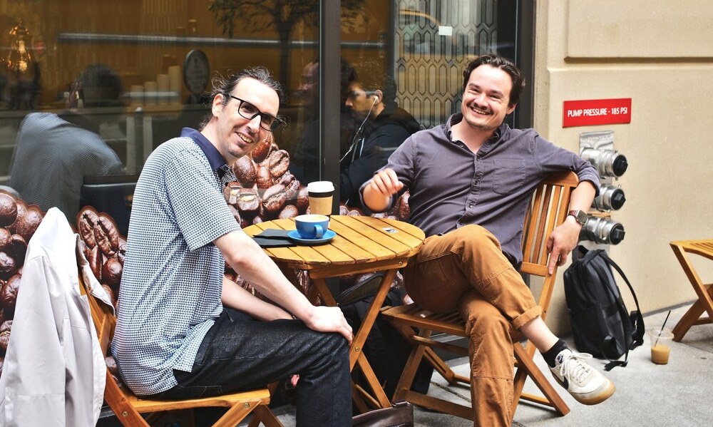 A photo of Laurent and Michael in San Francisco, on the patio of a coffee shop.